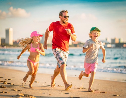 Family Running on Beach at Sunset