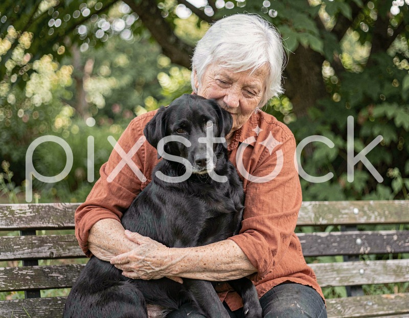 Senior Woman Hugging Black Dog