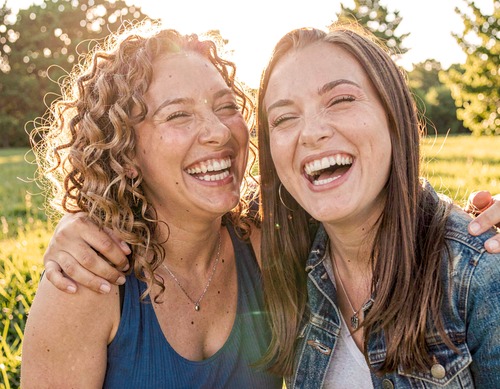 Two Friends Laughing in Sunlight