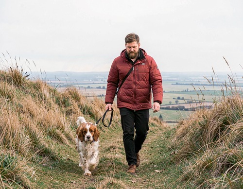 Man Walking Dog on Hillside