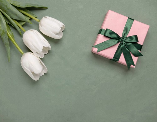 White Tulips and Pink Gift on Green Background