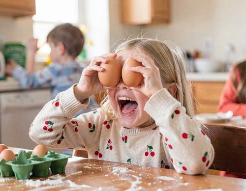 Child Playing with Eggs in Kitchen