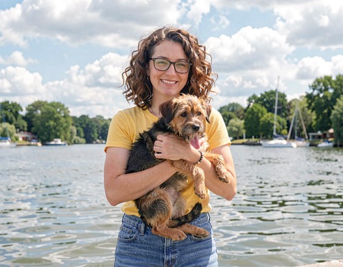 Woman Holding Dog by Lake