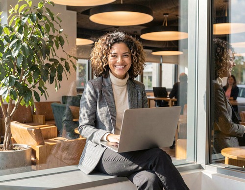 Businesswoman with Laptop by Office Window