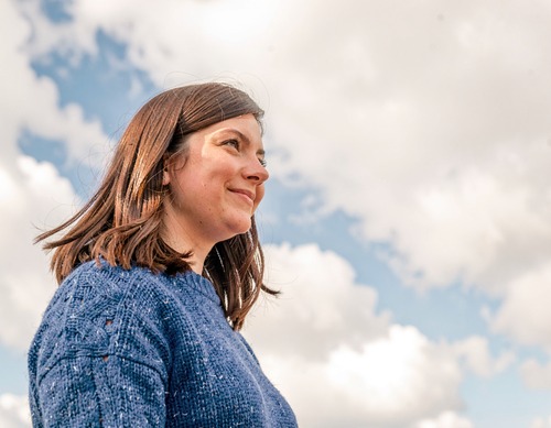 Woman in Blue Sweater Against Sky