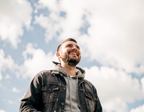 Man Smiling Against Sky