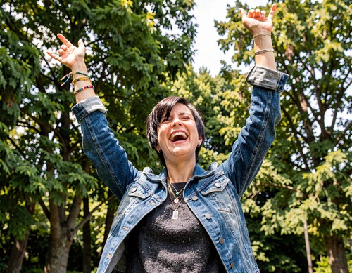Joyful Woman with Arms Raised in Nature