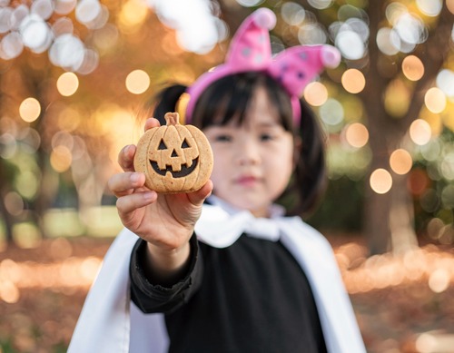 Child Holding Halloween Pumpkin Cookie