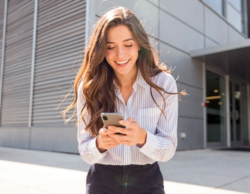 Smiling Woman with Smartphone Outdoors