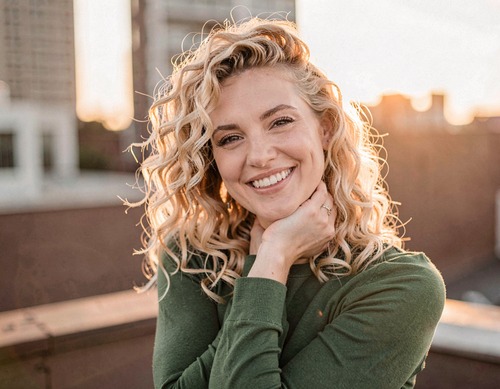 Smiling Woman with Curly Hair at Sunset