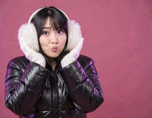 Asian Woman in Black Puffer on Hot Pink Background