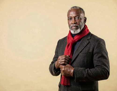 Bearded Black Man in Charcoal Overcoat on Yellow Backdrop