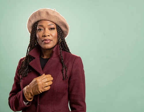 Black Woman in Burgundy Coat on Mint Background