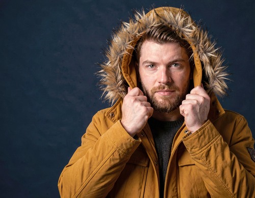 Man in Mustard Parka on Navy Background