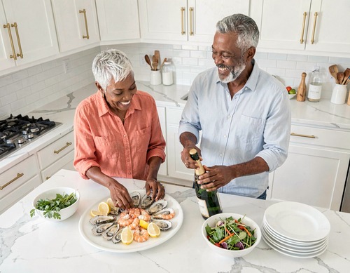 Mature Black Couple Cooking in Bright White Kitchen