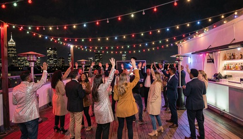 Rooftop Party Dancers Under Colorful String Lights
