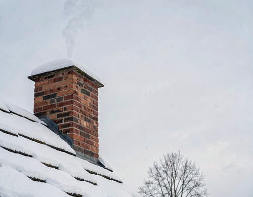 Snow-Covered Chimney on Brick House