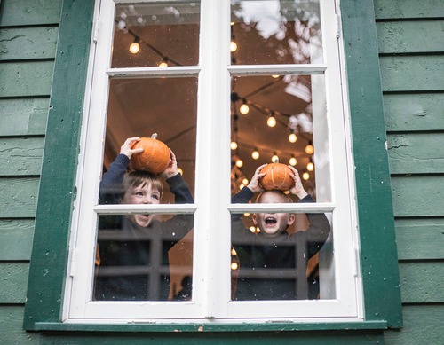 Children with Pumpkin by Window