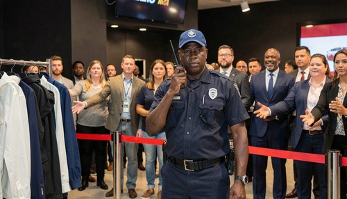 Security Guard Using Walkie-Talkie at Red Rope Barrier