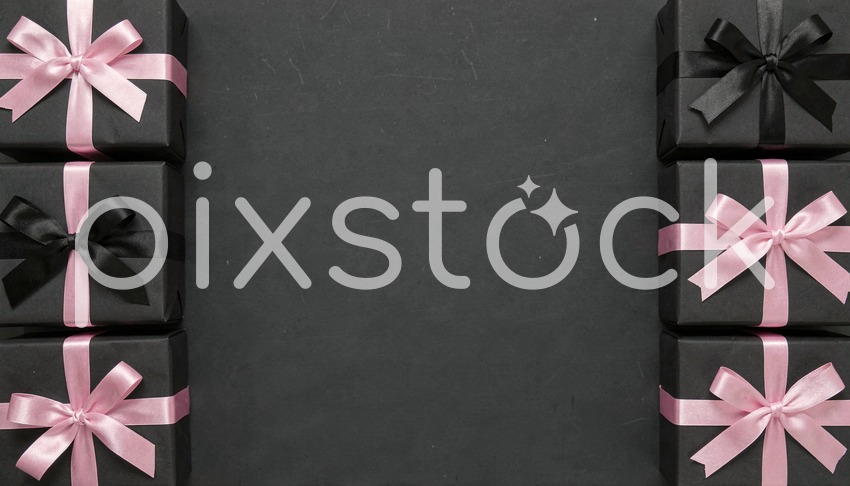 Black Gift Boxes with Pink Ribbons Arranged on Dark Background