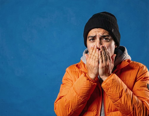 Young Man in Orange Puffer on Cobalt Background